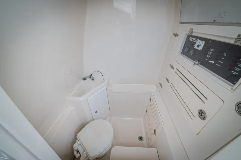 Half Nelson Yacht Photos Pics Compact marine bathroom in 2016 Jupiter HFS boat with toilet, sink, and control panel.