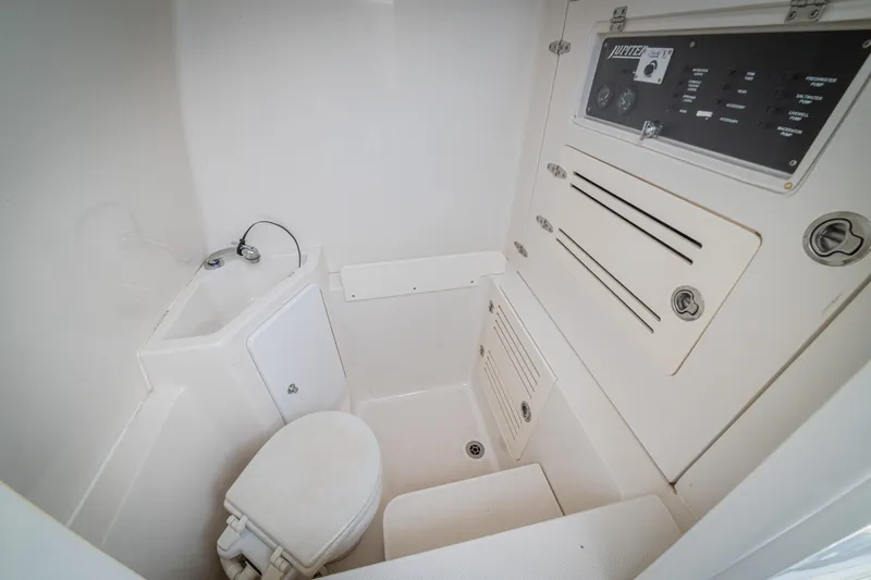 Half Nelson Yacht Photos Pics Compact marine bathroom in 2016 Jupiter HFS boat, featuring toilet and control panel.