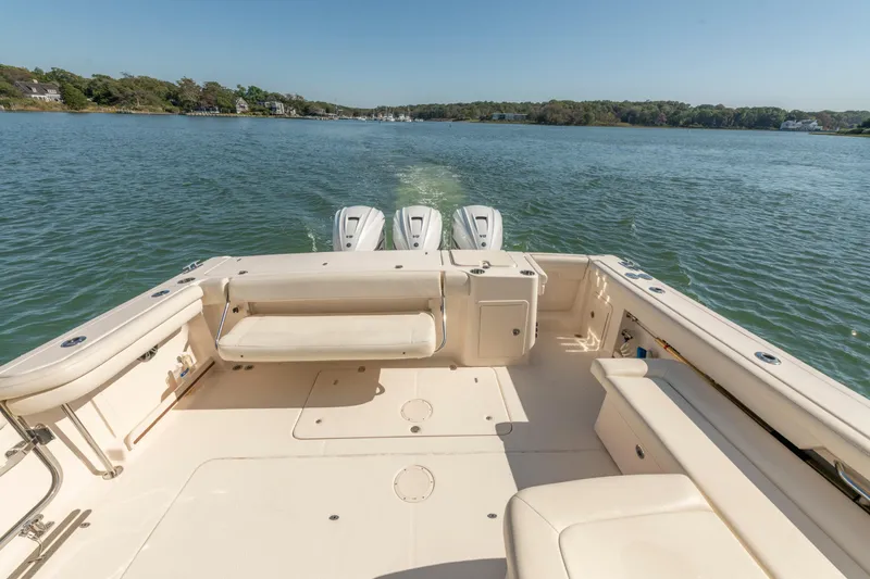 Yacht Photos Pics 2019 Grady-White Freedom 375 boat on calm water, showcasing spacious deck and triple engines.