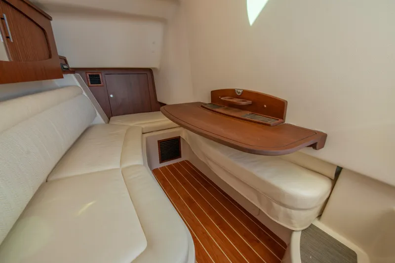  Yacht Photos Pics 2019 Grady-White Freedom 375 cabin interior with wooden table and cushioned seating.
