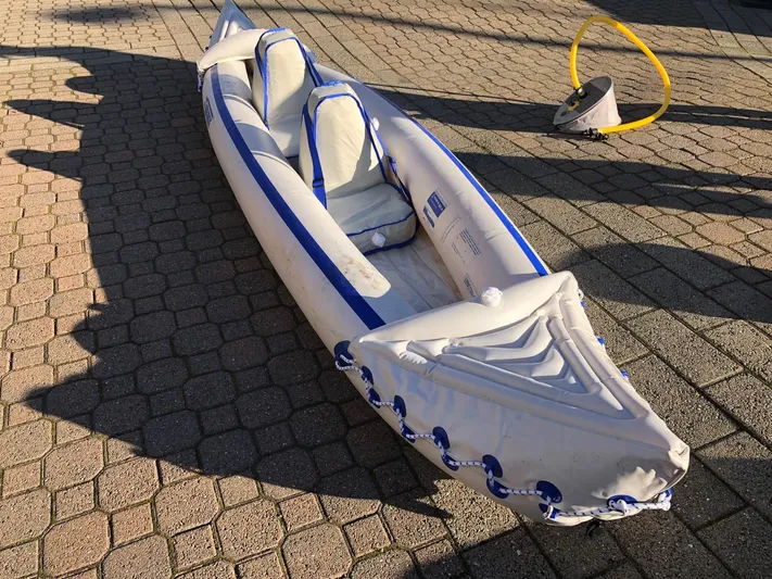 Papa Bob Yacht Photos Pics Inflatable kayak on paved surface with foot pump nearby.