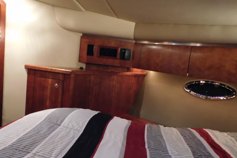 Just One More Yacht Photos Pics Interior cabin of 2005 Cruisers Yachts 520 Express with wood cabinetry and striped bedding.