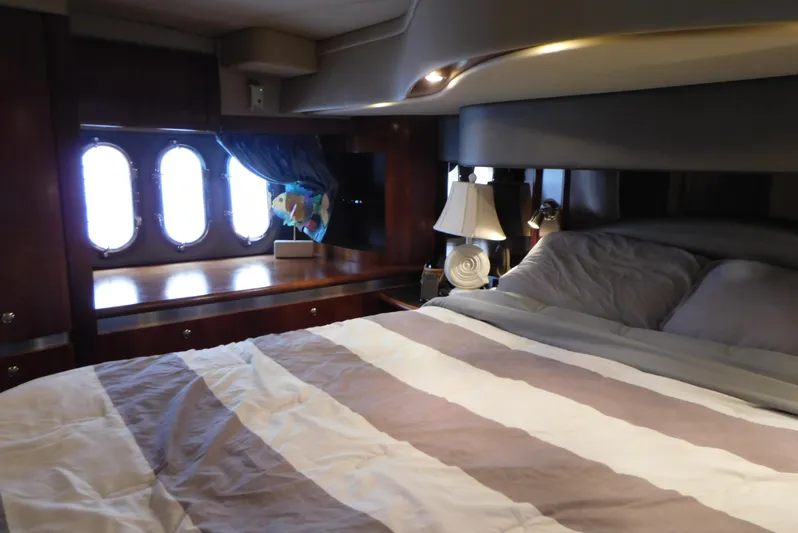 Just One More Yacht Photos Pics Luxurious bedroom interior of 2005 Cruisers Yachts 520 Express with striped bedding and porthole windows.