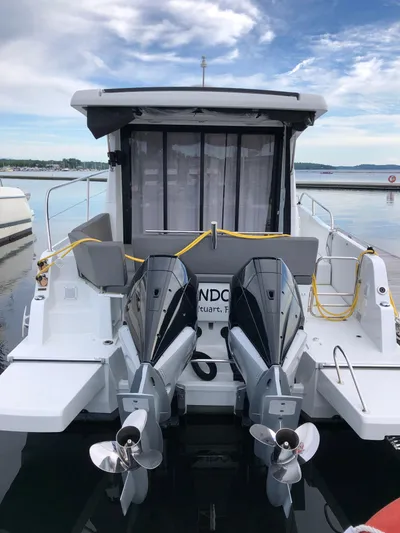 Boondoggle Yacht Photos Pics 2022 Beneteau Antares 11 with dual outboard motors docked at a marina.