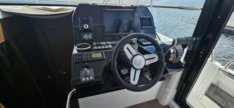 Boondoggle Yacht Photos Pics Cockpit of 2022 Beneteau Antares 11 with steering wheel and navigation controls.