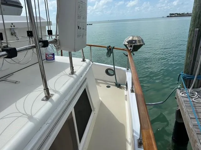 Blue Yacht Photos Pics 1987 Albin Double Cabin boat docked by calm waters, featuring wooden railings and marine equipment.