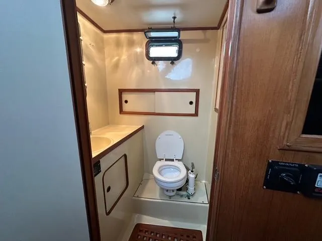 Blue Yacht Photos Pics 1987 Albin Double Cabin bathroom with toilet, sink, and wooden accents.