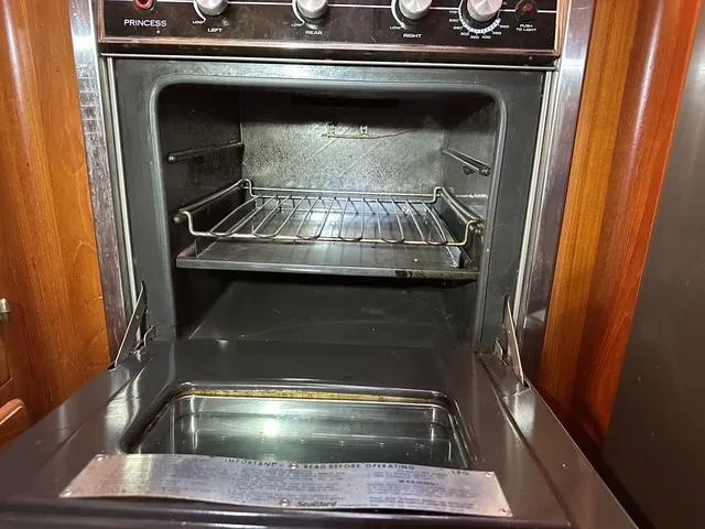 Blue Yacht Photos Pics Open oven inside 1987 Albin Double Cabin boat, featuring metal rack and control knobs.