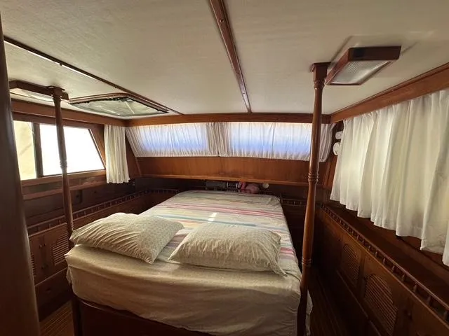 Blue Yacht Photos Pics 1987 Albin Double Cabin interior with bed, wooden finish, and curtained windows.