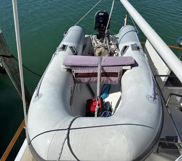 Blue Yacht Photos Pics Inflatable boat on 1987 Albin Double Cabin yacht, docked on calm water.