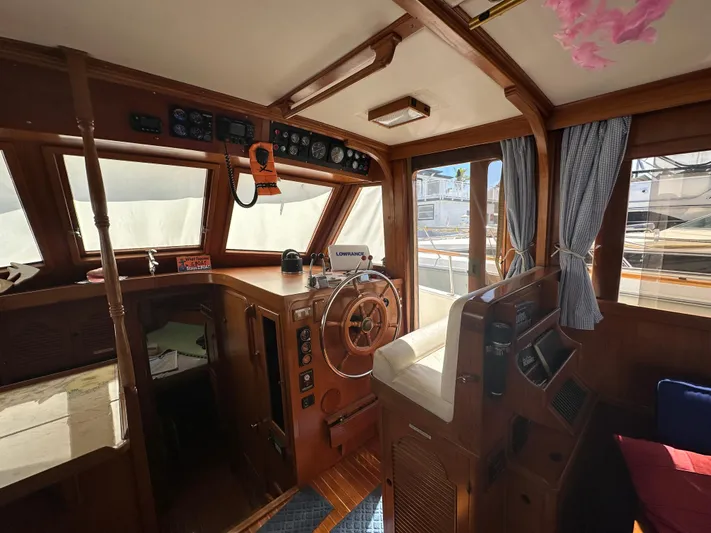 Blue Yacht Photos Pics Interior of a 1987 Albin Double Cabin boat with wooden helm and nautical instruments.