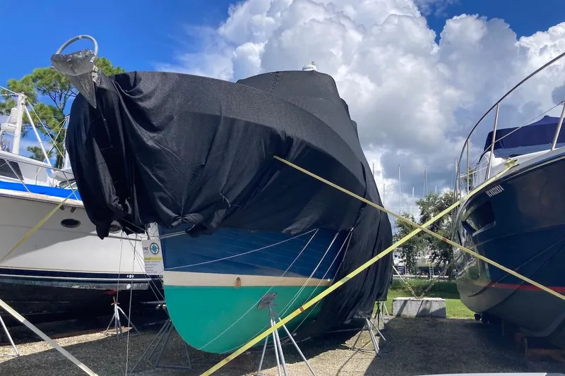 Blue Yacht Photos Pics 1987 Albin Double Cabin Trawler covered, docked under a cloudy sky.
