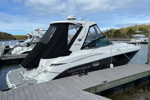  Yacht Photos Pics 2021 Monterey 335 Sport Yacht docked, featuring sleek design and black canopy.