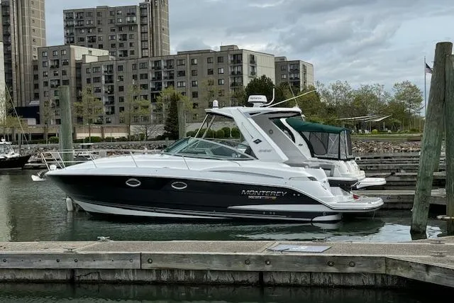  Yacht Photos Pics 2021 Monterey 335 Sport Yacht docked in urban marina with buildings in background.