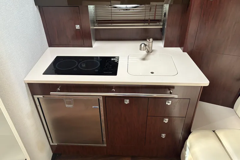 Yacht Photos Pics Modern kitchenette in 2021 Monterey 335 Sport Yacht with stove, sink, and storage.