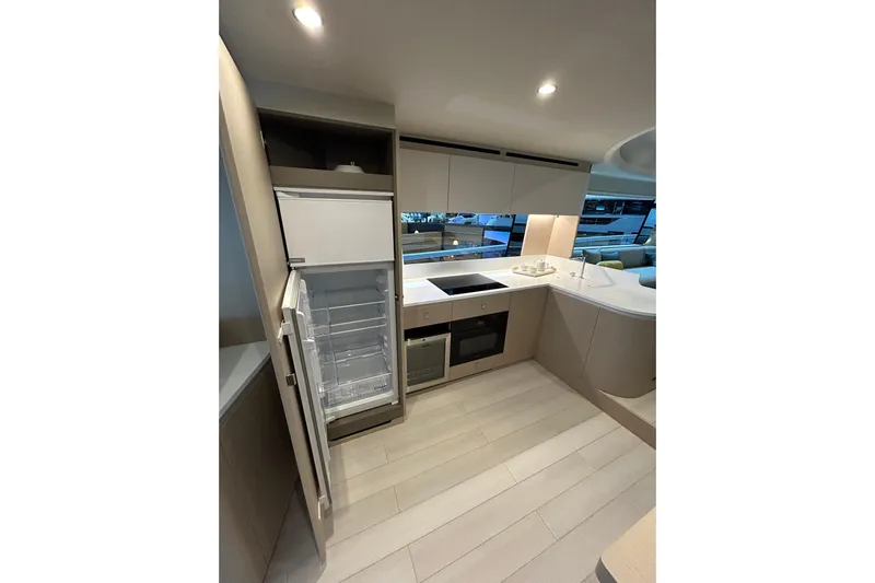  Yacht Photos Pics Modern kitchen interior of 2024 Azimut Fly 68 yacht with open fridge and sleek design.