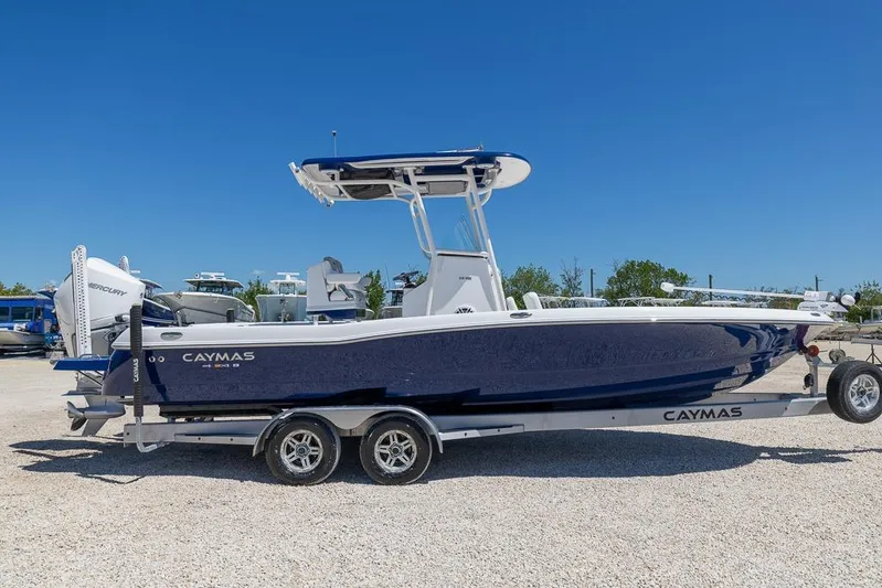  Yacht Photos Pics 2022 Caymas 26 HB boat on trailer, blue hull, parked outdoors under clear sky.