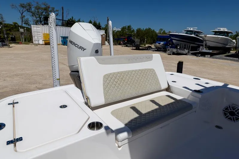  Yacht Photos Pics 2022 Caymas 26 HB boat with Mercury engine, featuring cushioned seating and storage compartments.