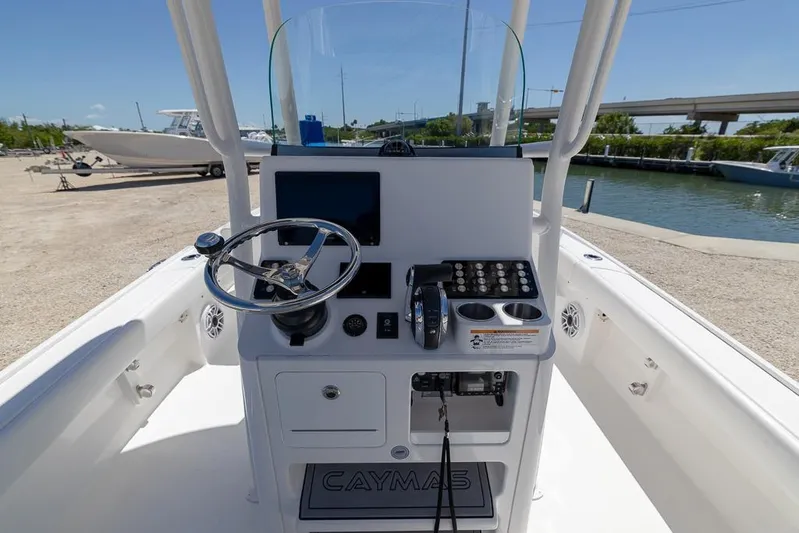  Yacht Photos Pics 2022 Caymas 26 HB boat console with steering wheel and controls, docked near water.