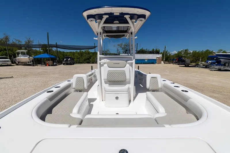  Yacht Photos Pics 2022 Caymas 26 HB boat interior with seating and console, parked outdoors under clear sky.