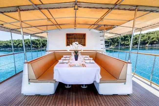 Clara One Yacht Photos Pics Luxurious dining setup on a 1961 Custom 90 yacht with scenic ocean view.