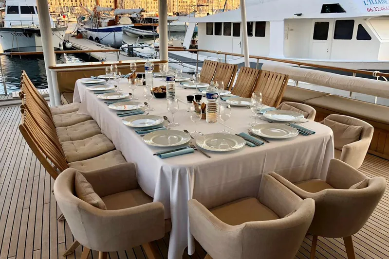Clara One Yacht Photos Pics Luxurious yacht dining setup with elegant tableware, Custom 90 model, 1961, docked at marina.