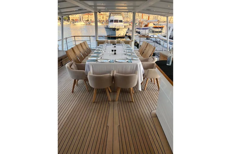 Clara One Yacht Photos Pics Luxurious yacht dining setup on a 1961 Custom 90, featuring elegant tableware and waterfront views.
