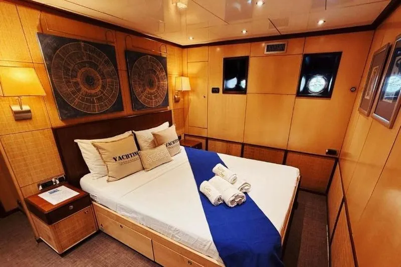 Clara One Yacht Photos Pics Luxurious yacht cabin interior with wooden paneling, cozy bed, and nautical decor, Custom 90, 1961.