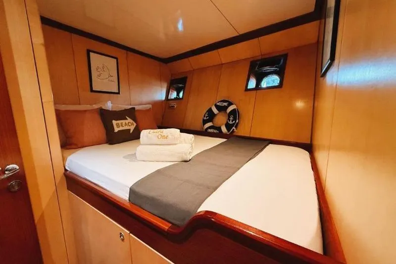 Clara One Yacht Photos Pics Cozy cabin interior on a 1961 Custom 90 yacht with nautical decor and plush bedding.