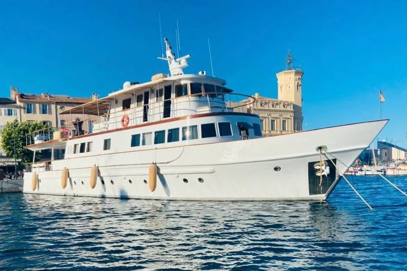 Clara One Yacht Photos Pics Custom 90 yacht from 1961 docked in a sunny harbor with clear blue skies.