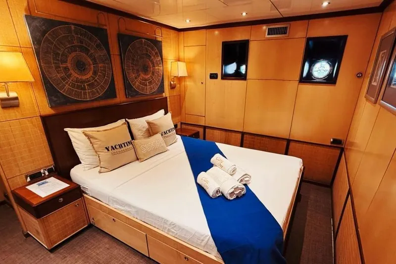 Clara One Yacht Photos Pics Luxurious yacht bedroom with elegant decor, featuring a comfortable bed and nautical-themed artwork.