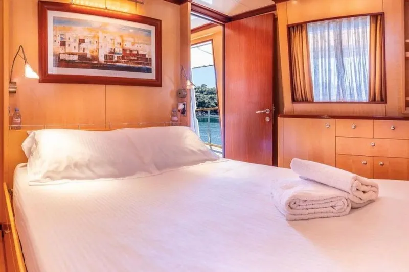 Clara One Yacht Photos Pics Luxurious cabin interior on a 1961 Custom 90 yacht with cozy bed and scenic view.
