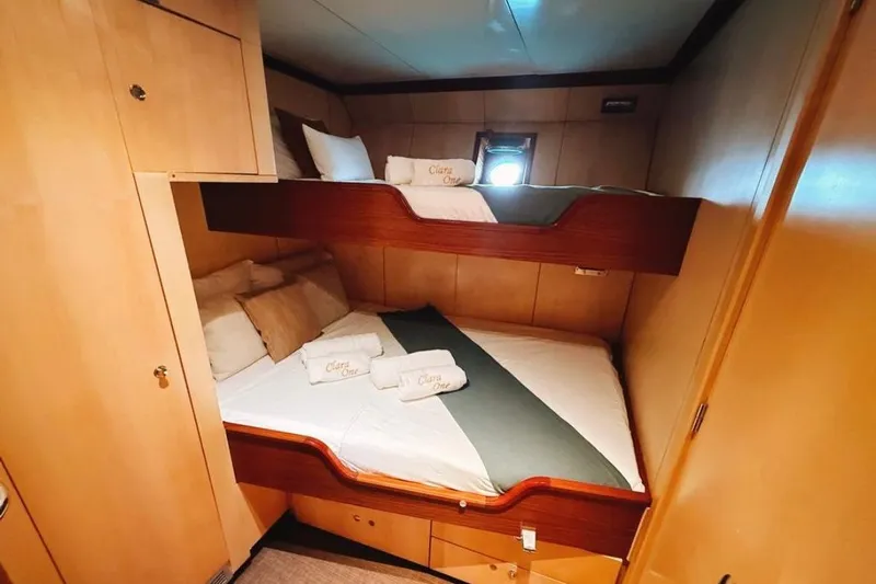Clara One Yacht Photos Pics Cozy cabin with bunk beds on a 1961 Custom 90 yacht, featuring elegant wood paneling.