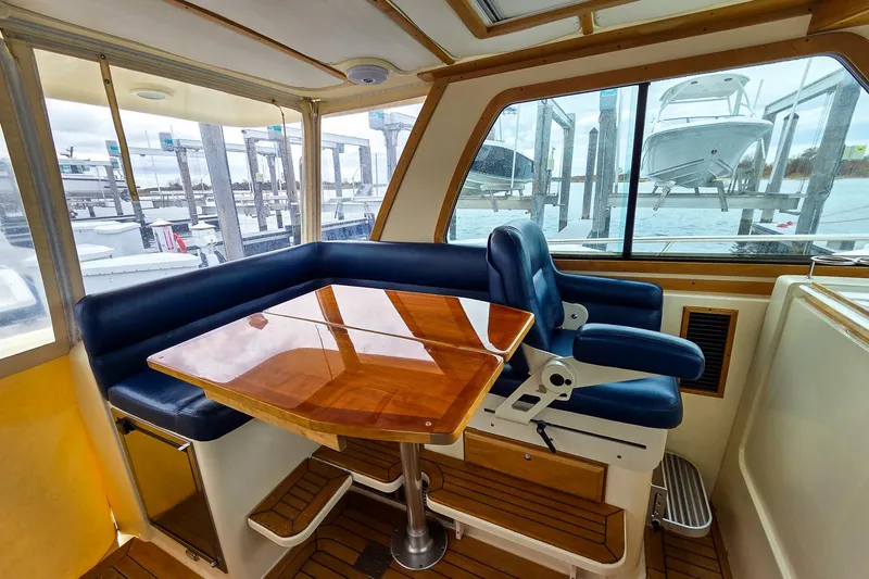  Yacht Photos Pics Interior of 2008 Sabre 34 Express yacht with blue seating and wooden table.
