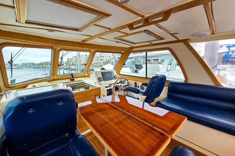  Yacht Photos Pics Interior of 2008 Sabre 34 Express yacht with wooden table and blue seating.