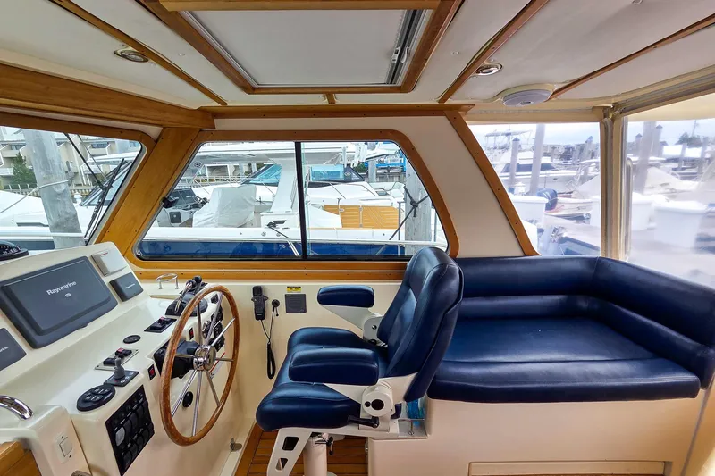  Yacht Photos Pics 2008 Sabre 34 Express boat interior with helm, blue seating, and marina view.