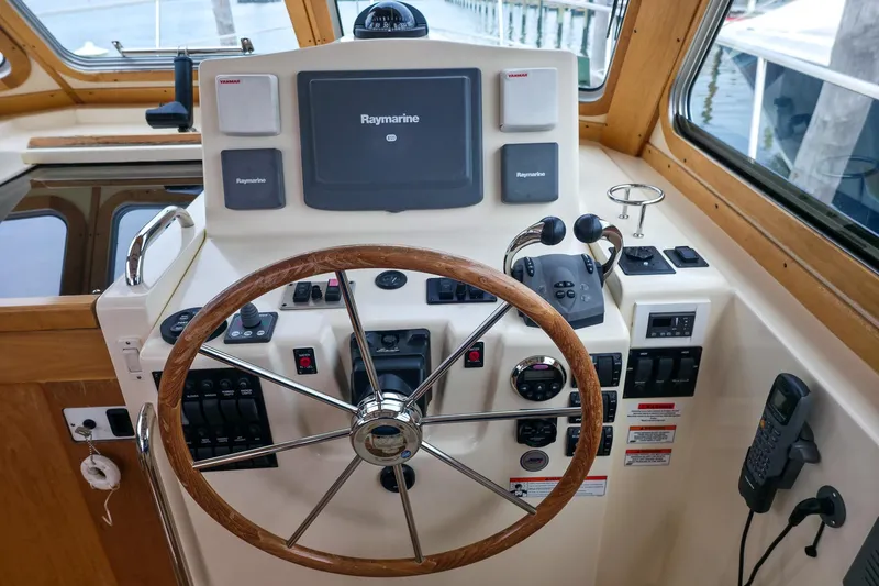  Yacht Photos Pics 2008 Sabre 34 Express helm with Raymarine navigation, wooden steering wheel, and control panel.