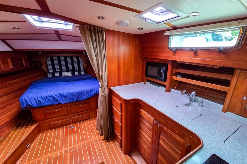  Yacht Photos Pics Luxurious 2008 Sabre 34 Express yacht interior with wood finish, cozy bed, and kitchenette.
