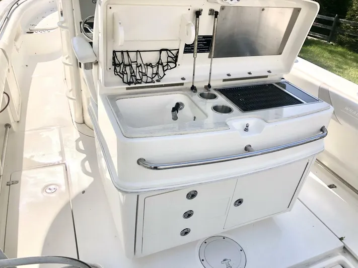  Yacht Photos Pics 2016 Boston Whaler OUTRAGE boat interior with sink and storage compartments.