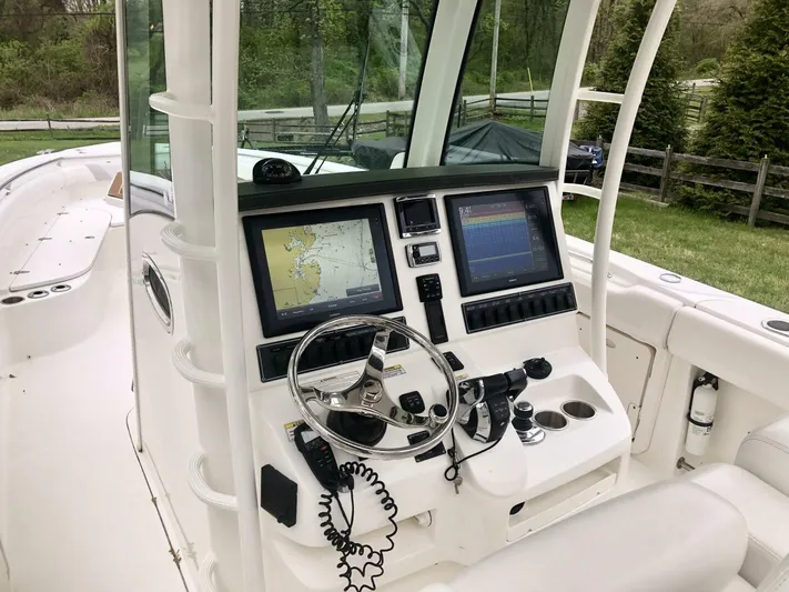  Yacht Photos Pics 2016 Boston Whaler OUTRAGE boat cockpit with navigation screens and steering wheel.