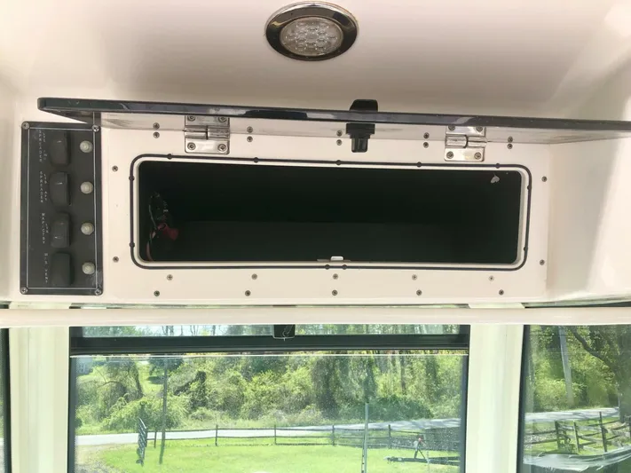  Yacht Photos Pics 2016 Boston Whaler OUTRAGE storage compartment with open hatch and control panel.