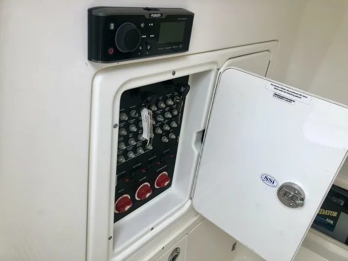  Yacht Photos Pics Electrical panel inside a 2016 Boston Whaler OUTRAGE boat, featuring control switches and a Fusion stereo.