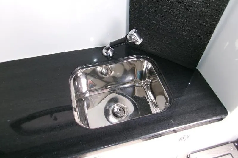  Yacht Photos Pics Stainless steel sink on 2026 Monterey Elite 30 OB boat, sleek black countertop.