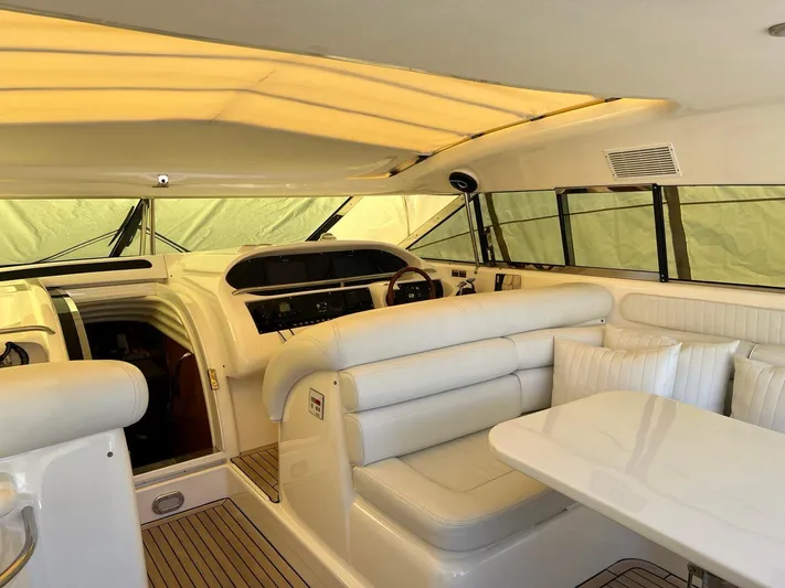 1299 Yacht Photos Pics Luxurious interior of a 1996 Sunseeker Predator 63 yacht with white seating and helm.