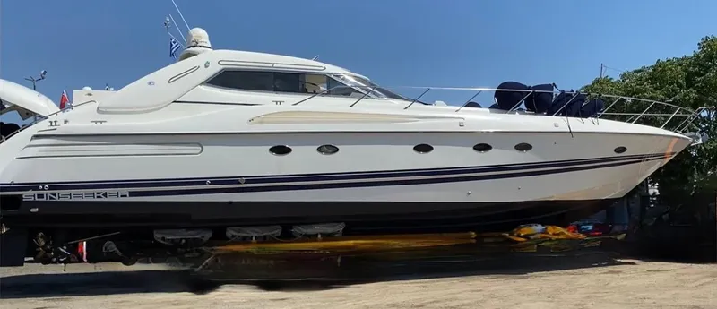 1299 Yacht Photos Pics 1996 Sunseeker Predator 63 yacht on dry dock under clear blue sky.