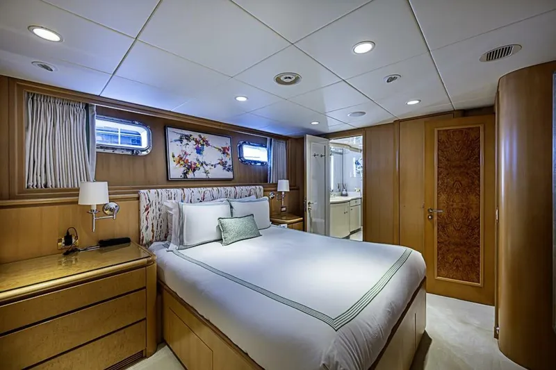 Probability Yacht Photos Pics Luxurious bedroom interior on 1997 Delta 122 Tri-Deck Motor Yacht, featuring elegant wood paneling.