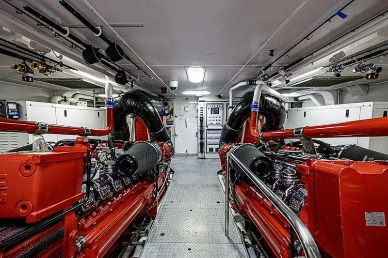 Probability Yacht Photos Pics Engine room of 1997 Delta 122 Tri-Deck Motor Yacht, featuring red machinery and control panels.