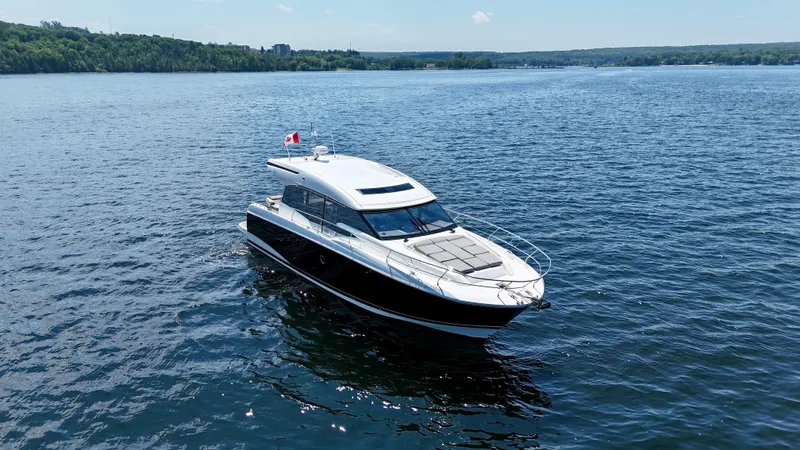  Yacht Photos Pics 2023 Prestige 520S yacht cruising on a serene lake under a clear blue sky.