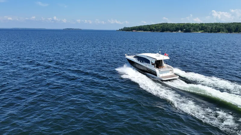  Yacht Photos Pics 2023 Prestige 520S yacht cruising on a clear blue lake under a sunny sky.
