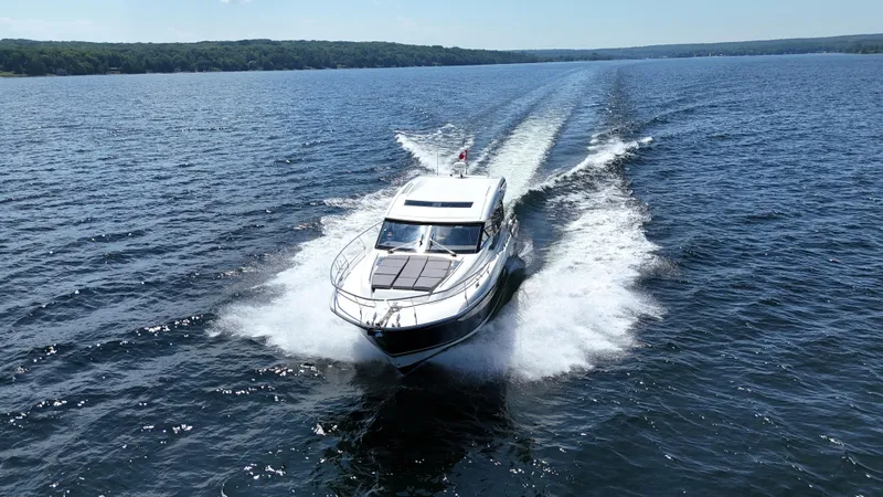 Yacht Photos Pics 2023 Prestige 520S yacht cruising on a serene lake under a clear sky.